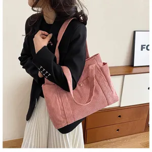 Dettaglio della borsa tote in velluto a coste rosa con tessuto strutturato e tracolla.