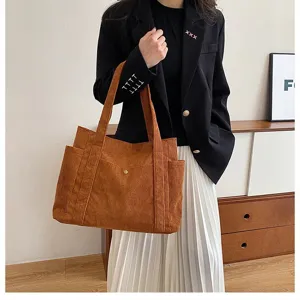 Vista dettagliata della borsa tote in velluto a coste marrone con grande capacità e stile.