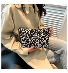 Detailansicht einer stilvollen Kosmetiktasche mit Leopardenmuster, von Hand gehalten