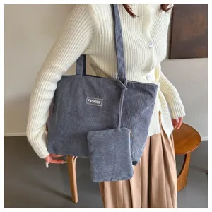 Detalle de un bolso tote de pana gris con neceser a juego para el uso diario