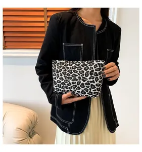 Nahaufnahme der modischen Make-up-Clutch mit Leopardenmuster, gehalten von einem Model