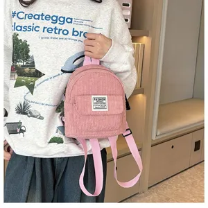 Detailed view of pink corduroy mini backpack with fashion label and soft texture