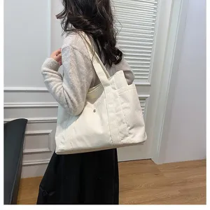 Grande borsa tote in velluto a coste bianco indossata per riferimento misura