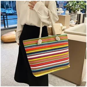 Kleurrijke gestreepte etnische canvas shopper met witte touwhandvatten op model