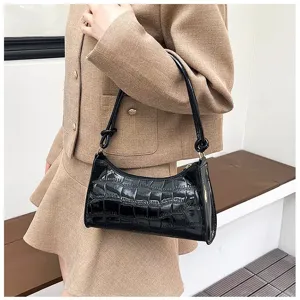 Close-up of black glossy stone pattern underarm bag for women worn with beige suit