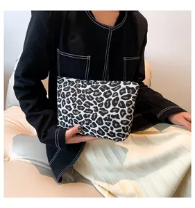Modische Kosmetiktasche mit Leopardenmuster, gezeigt von einem Model für stilvolle Aufbewahrung.