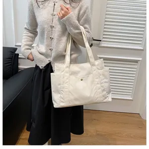 Borsa tote in velluto a coste bianco da donna mostrata in un ambiente interno reale