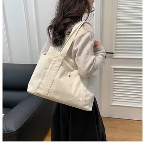 Grande borsa tote in velluto a coste crema da donna in un ambiente interno lifestyle