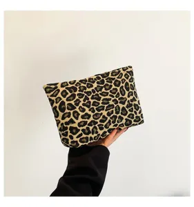 Detailansicht einer modischen Clutch mit Leopardenmuster, minimalistisch von Hand gehalten