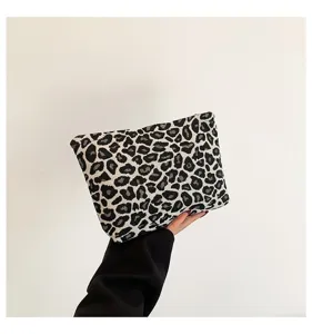 Detailansicht der stylischen Kosmetiktasche mit Leopardenmuster, gehalten von einer Hand