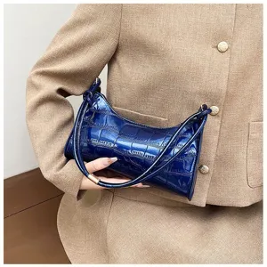 Close-up view of a stylish blue glossy crocodile embossed underarm bag for women