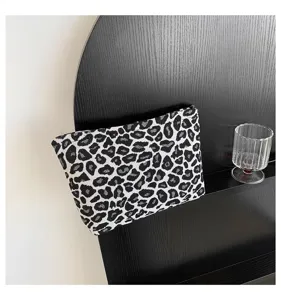 Nahaufnahme einer modischen Clutch mit Leopardenmuster vor schwarzem Hintergrund