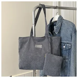 Vista detallada de la textura del bolso tote de pana gris con bolsa pequeña a juego