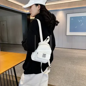 White corduroy mini backpack for women, stylish and casual design for outdoor travel.
