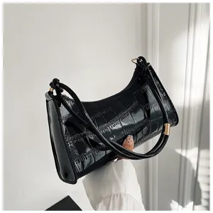 Black stone pattern underarm bag with glossy finish held by hand