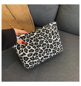 Detailansicht der Clutch mit Leopardenmuster, die Textur und die Größe der Tasche zeigt.
