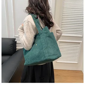 Vista dettagliata della borsa tote in velluto a coste verde scuro capiente