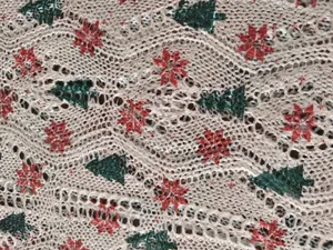 Primo piano del tessuto maglione a maglia traforata con alberi di Natale e fiocchi