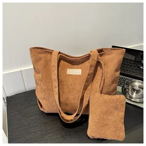 Primer plano del conjunto de bolso tote de pana marrón con bolsa a juego