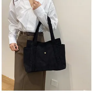Elegante borsa tote in velluto a coste nero ad alta capacità tenuta da una modella