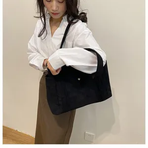 Scatto dettagliato della trama di una borsa tote in velluto a coste nero su modella