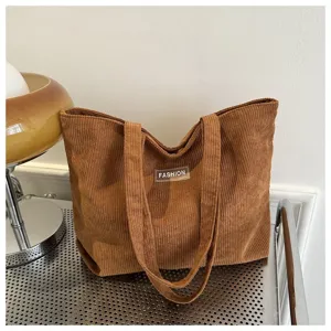 Vista detallada de un bolso tote de pana marrón con parche Fashion y textura suave