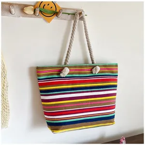 Gedetailleerd overzicht van een kleurrijke gestreepte canvas draagtas met bohemien touwhandvatten