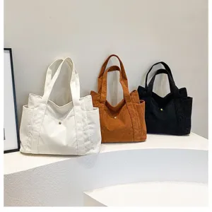 Tre colori di eleganti borse tote in velluto a coste in crema, marrone e nero quotidiano.