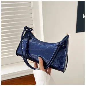 Detailed view of a glossy dark blue underarm bag featuring an elegant stone pattern texture
