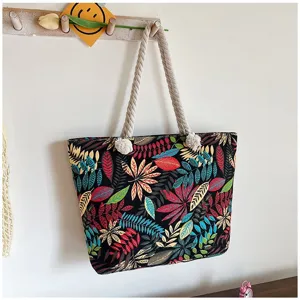 Detailweergave van een etnische canvas tas met bladprint en touwhandvatten