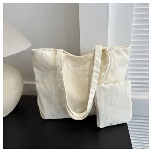 Bolso tote minimalista de pana color crema con neceser a juego para el día a día.