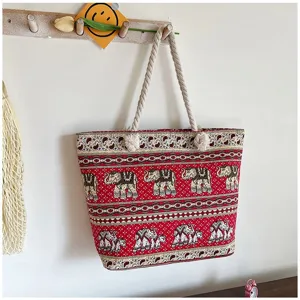 Boheemse rode canvas draagtas met olifantenprint en touwhandvatten aan de muur hangend