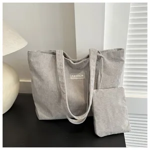 Bolso tote de pana gris con neceser a juego en una decoración de hogar minimalista