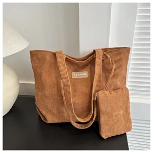 Detalle de un bolso tote de pana marrón con su pequeña bolsa de mano a juego