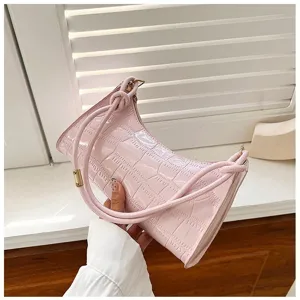 Detailed view of pink croc-textured underarm bag with minimalist shoulder strap