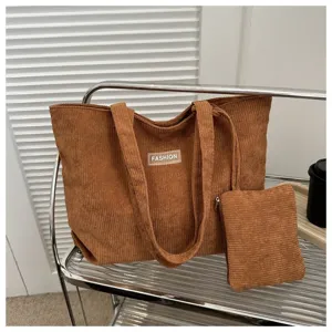 Vista detallada del bolso tote de pana marrón y de su pequeña bolsa de accesorios a juego.