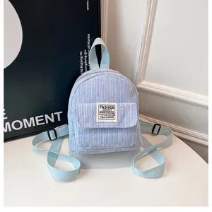 Close-up of a stylish light blue corduroy mini backpack for women with front pocket