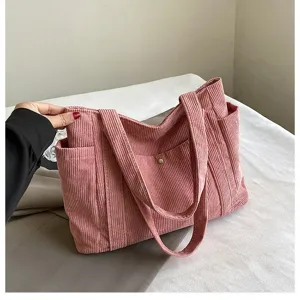 Dettaglio di una borsa tote in velluto a coste rosa con trama a costine e grande capacità