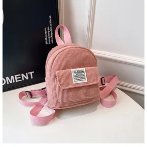 Detailed macro shot of a stylish pink corduroy mini backpack with adjustable straps