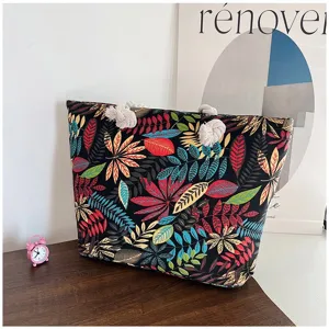 Gedetailleerd zicht op de etnische canvas draagtas met levendige bloemenprint