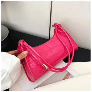 Close-up of bright pink baguette bag featuring premium stone-textured patent leather