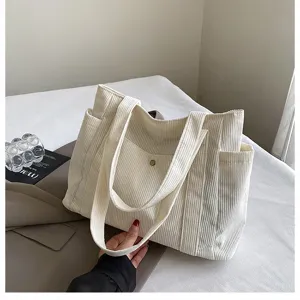 Dettaglio di una grande borsa tote in velluto a coste bianco con texture e tasca