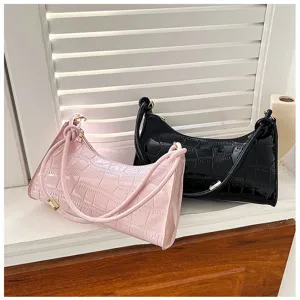 Detailed view of trendy pink and black crocodile-embossed underarm shoulder bags for women