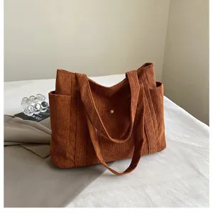 Vista dettagliata della borsa tote in velluto a coste marrone con ampie tasche