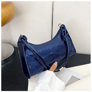 Detail view of a navy blue stone pattern underarm bag with glossy patent leather finish.