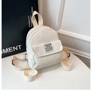 Macro detail of cream corduroy small backpack with fashion instinct logo patch