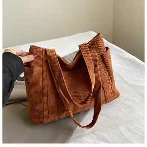 Primo piano della borsa tote in velluto a coste marrone con trama e tasca laterale
