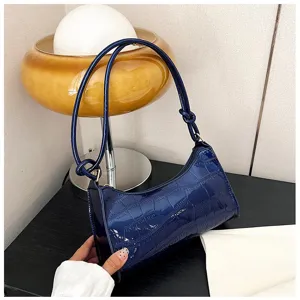 Close-up detail showing the glossy blue crocodile texture and elegant knot handle design