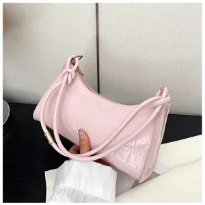 Detailed view of a pink croc-embossed underarm bag with unique knot shoulder strap.