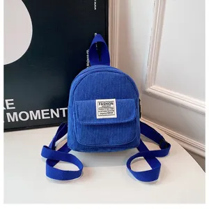 Detailed macro view of vibrant blue corduroy small backpack with ribbed texture.